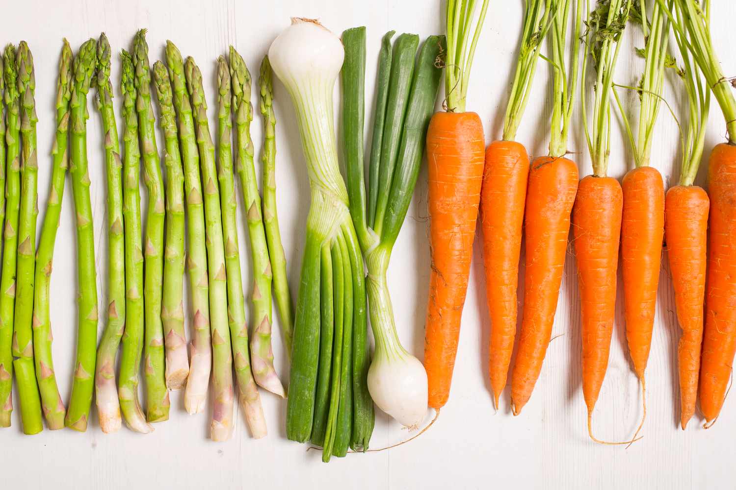 A vibrant spread of colourful vegetables, grains, and legumes arranged on a wooden surface